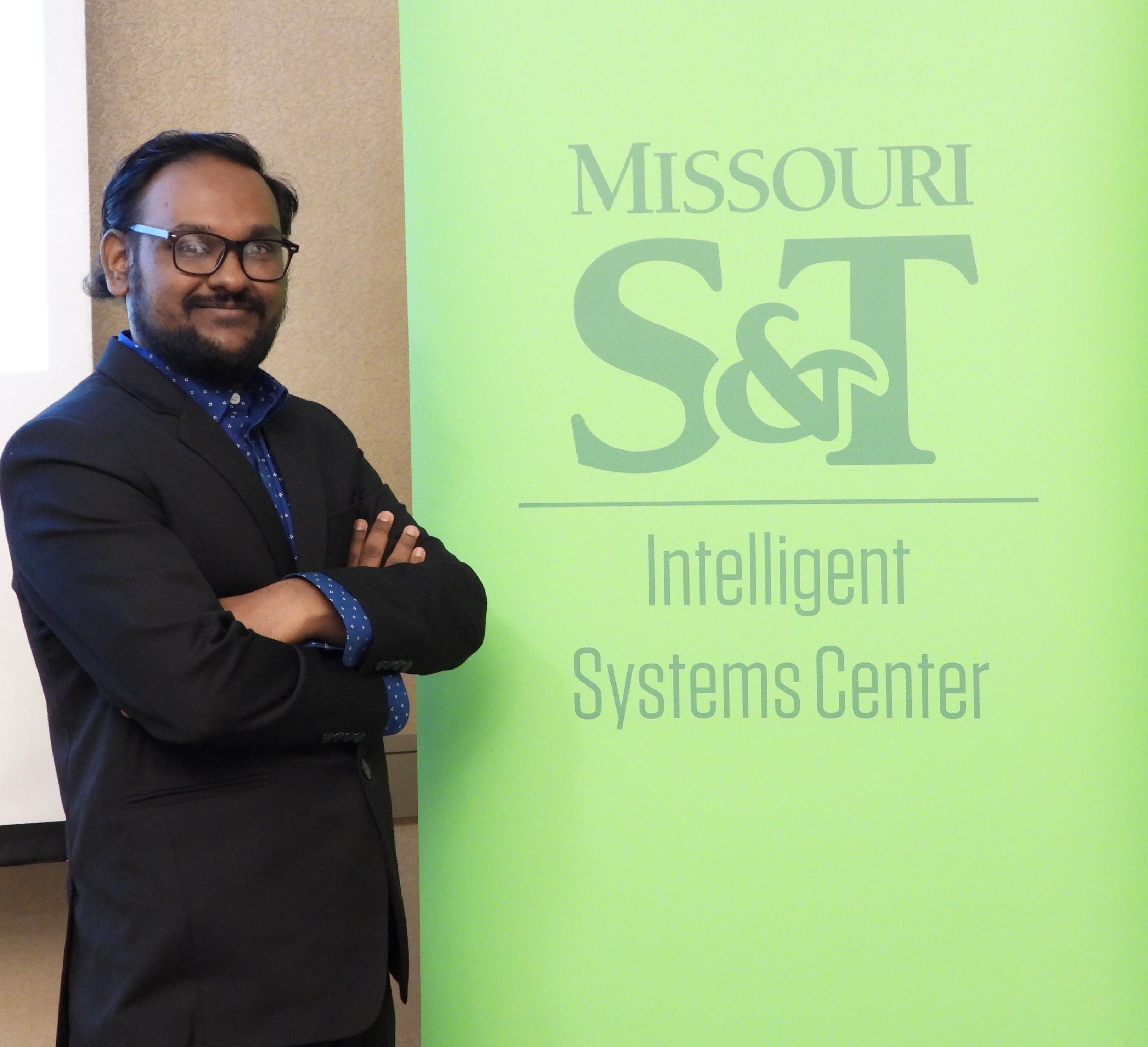 Third place recipient, Tazdik Patwary Plateau, smiling in front of Intelligent Systems Center banner.